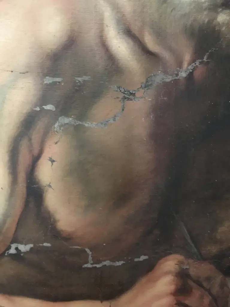 Detalle del torso de San Jerónimo, óleo sobre lienzo, antes de la restauración: grietas horizontales con pérdidas de pintura en el pecho y el brazo.